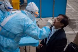 Nhân viên y tế lấy mẫu xét nghiệm COVID-19 cho người dân tại Bắc Kinh, Trung Quốc. (Ảnh: AFP/TTXVN)