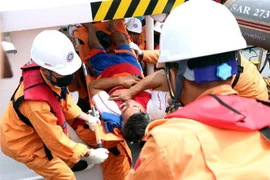 Lực lượng cứu hộ đưa thuyền viên về bờ. (Ảnh: Trần Hoàng Ngọc/TTXVN)