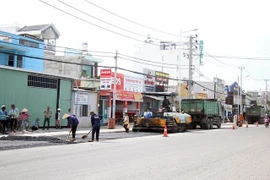 Các đơn vị thi công thảm nhựa tại dự án nâng cấp, mở rộng đường Tô Ký, Hóc Môn, TP.HCM. (Ảnh: Tiến Lực/TTXVN)