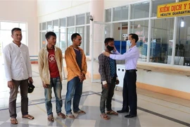 Hướng dẫn người dân ở Gia Lai sử dụng khẩu trang phòng chống dịch. (Ảnh: Hoài Nam/TTXVN)