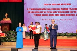 Bí thư Thành ủy Thành phố Hồ Chí Minh Nguyễn Thiện Nhân tặng Bằng khencho đại diện tập thể có thành tích xuất sắc. (Ảnh: Xuân Khu/TTXVN)