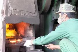 Dù thời tiết nắng nóng, hàng trăm con người ở làng rèn Tiến Lộc (Thanh Hóa) vẫn lao động, kiếm kế sinh nhai bên những chiếc lò lửa đỏ rực. (Ảnh: Khiếu Tư/TTXVN)
