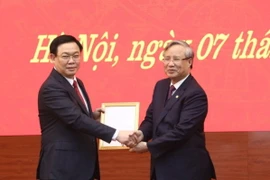 Thường trực Ban Bí thư Trần Quốc Vượng trao quyết định bổ nhiệm ông Vương Đình Huệ làm Bí thư Thành ủy Hà Nội. (Ảnh: Văn Điệp/TTXVN)