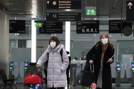 Hành khách đeo khẩu trang phòng dịch COVID-19. (Ảnh: AFP/TTXVN)