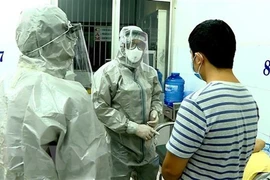 Nhân viên y tế thực hiện các biện pháp nghiệp vụ với bệnh nhân nghi mắc nCoV. (Ảnh: Thành Chung/TTXVN)