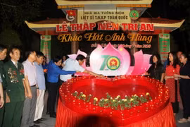 Các đại biểu thực hiện nghi lễ 'Thắp nến tri ân.' (Ảnh: Phan Quân/TTXVN)