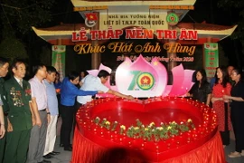 Các đại biểu thực hiện nghi lễ 'Thắp nến tri ân.' (Ảnh: Phan Quân/TTXVN)