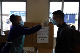  Nhân viên y tế kiểm tra thân nhiệt của hành khách. (Ảnh minh họa. Nguồn: TTXVN)