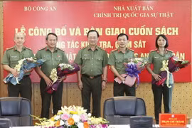 Phó giáo sư-tiến sỹ Nguyễn Văn Thành, Ủy viên Trung ương Đảng, Thứ trưởng Bộ Công an tặng hoa chúc Ban Biên soạn. (Ảnh: Doãn Tấn/TTXVN)
