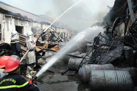 Lực lượng chức năng tiếp cận hiện trường, tích cực chữa cháy. (Ảnh: Nhật Anh/TTXVN)