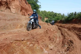 Cô Hà Thị Linh (đi đầu) giáo viên trường Tiểu học Hra số 2 trên đường lên điểm trường Đê Kôn trước năm học mới. (Ảnh: Hồng Điệp/TTXVN)