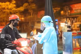 Nhân viên y tế kiểm tra và sát khuẩn cho những người vào bênh viện. (Ảnh: Dương Giang/TTXVN)
