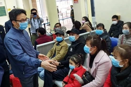 Phó Thủ tướng Vũ Đức Đam thăm hỏi bà con chờ nhập cảnh về Việt Nam tại khu vực cửa khẩu quốc tế Móng Cái. (Ảnh: Đức Hiếu/TTXVN)
