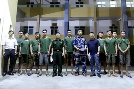 Đồn Biên phòng cửa khẩu cảng Hòn Gai bàn giao 9 thuyền viên gặp nạn cho công ty chủ quản. (Ảnh: TTXVN)