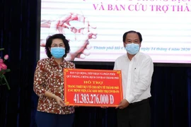 Bà Tô Thị Bích Châu, Chủ tịch Ủy ban MTTQ Việt Nam Thành phố trao tượng cho ông Nguyễn Hoài Nam, Phó Giám đốc Sở Y tế Thành phố số tiền ủng hộ để mua sắm trang thiết bị y tế (đợt 1) và hỗ trợ bác sỹ, y tá, nhân viên y tế tham gia công tác phòng, chống dịc