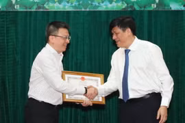 Thứ trưởng Bộ Y tế Nguyễn Thanh Long trao Bằng khen cho nhà báo Lê Quốc Minh, Phó Tổng Giám đốc TTXVN vì thành tích xuất sắc trong công tác thông tin, tuyên truyền về phòng, chống dịch COVID-19. (Ảnh: Thành Đạt/TTXVN)