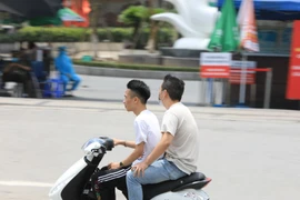 Một số người vẫn chủ quan không đeo khẩu trang khi đi qua Bệnh viện Bạch Mai (trước đây là tâm dịch). (Ảnh: Thành Đạt/TTXVN)