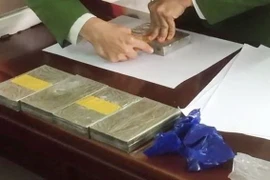 Tang vật 5 bánh heroin, 1.000 viên ma túy tổng hợp. (Ảnh: TTXVN)