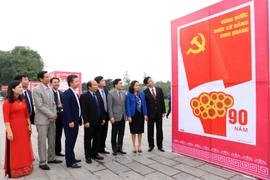 Các đại biểu tham quan khu vực trưng bày tranh cổ động chào mừng 90 năm thành lập Đảng và 70 năm thành lập tỉnh Vĩnh Phúc. (Ảnh: Hoàng Hùng/TTXVN)