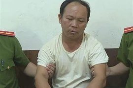 Đối tượng cùng tang vật tại cơ quan công an. (Ảnh: TTXVN)