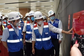 Lãnh đạo Ban Quản lý đường sắt đô thị giới thiệu hệ thống phòng cháy chữa cháy tại ga Nhà hát Thành phố của Dự án metro số 1. (Ảnh: Tiến Lực/TTXVN)