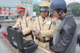 Cảnh sát giao thông tiến hành đo nồng độ cồn đối với người điều khiển phương tiện. (Ảnh: Vietnam+)