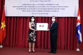 Bộ trưởng Bộ Xây dựng Phạm Hồng Hà, Thường trực Phân ban Việt Nam trong Ủy ban Liên Chính phủ hai nước trao tượng trưng 5.000 tấn gạo cho Đại sứ Cuba tại Việt Nam Lianys Torres. (Ảnh: Danh Lam/TTXVN)
