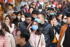 Đeo khẩu trang y tế ở những chỗ đông người để phòng ngừa virus corona. (Nguồn: TTXVN)