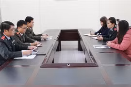 Lực lượng chức năng làm việc với người đăng thông tin sai sự thật (áo hồng) tại Sở Thông tin và Truyền thông tỉnh Phú Thọ. (Ảnh: Trung Kiên/TTXVN)