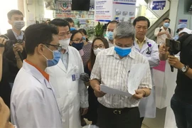 Thứ trưởng Bộ Y tế Nguyễn Trường Sơn kiểm tra quy trình thực hiện điều tra dịch tễ người bệnh tại một bệnh viện. (Ảnh: Đinh Hằng/TTXVN)