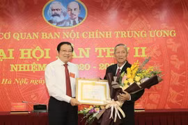 Ông Phan Đình Trạc, Bí thư Trung ương Đảng, Trưởng Ban Nội chính Trung ương, Phó Trưởng ban Thường trực Ban Chỉ đạo Trung ương về phòng, chống tham nhũng trao tặng Huy hiệu 55 tuổi Đảng cho ông Trương Vĩnh Trọng. (Ảnh: Doãn Tấn/TTXVN)