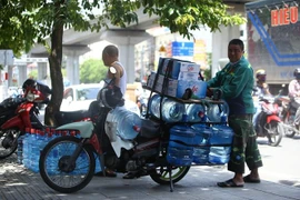 Các đại lý nước sạch đóng bình luôn bận rộn trong những ngày nắng nóng. (Ảnh: Minh Quyết/TTXVN)