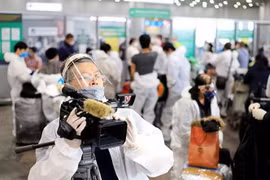 Phóng viên thường trú của TTXVN tại Moskva (LB Nga) ghi hình sự kiện đưa hơn 300 công dân Việt Nam từ Liên bang Nga về nước tại sân bay Sherementyevo, tháng 5/2020. (Ảnh: TTXVN)