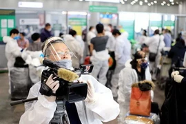 Phóng viên thường trú của TTXVN tại Moskva (LB Nga) ghi hình sự kiện đưa hơn 300 công dân Việt Nam từ Liên bang Nga về nước tại sân bay Sherementyevo, tháng 5/2020. (Ảnh: TTXVN)