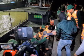 Các ngư dân gặp nạn được đưa vào bờ an toàn. (Ảnh: Trịnh Duy Hưng/TTXVN)