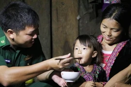 Cán bộ, chiến sỹ biên phòng cắm bản cùng ăn, cùng ở với dân bản. (Ảnh: Quý Trung/TTXVN)