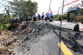 Các đại biểu tham dự hội nghị đi khảo sát thực tế tại điểm sạt lở. (Ảnh: Huỳnh Thế Anh/TTXVN)