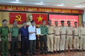 Ông Bùi Văn Cường (áo trắng), Ủy viên Trung ương Đảng, Bí thư Tỉnh ủy Đắk Lắk trao thư khen Công an tỉnh Đắk Lắk. (Ảnh: TTXVN)