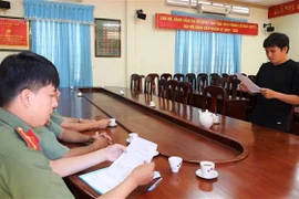 Nguyễn Hữu Thủy nhận quyết định xử phạt hành chính về hành vi tung tin sai sự thật về bệnh COVID-19. (Ảnh: Thanh Tân/TTXVN)