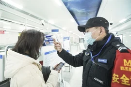 Kiểm tra thân nhiệt một hành khách nhằm ngăn chặn sự lây lan của dịch viêm đường hô hấp cấp do virus corona chủng mới (2019-nCoV) tại nhà ga đường sắt Vũ Hán, tỉnh Hồ Bắc, Trung Quốc. (Ảnh: THX/TTXVN_