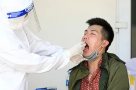 Lấy mẫu dịch hầu họng để xét nghiệm RT-PCR tại Trung tâm Văn hóa Thông tin và Thể Thao quận Đống Đa (237 Đặng Tiến Đông) - nơi xét nghiệm cho người dân quận Đống Đa trở về từ Đà Nẵng. (Ảnh: Thành Đạt/TTXVN)