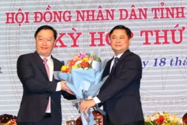 Ông Thái Thanh Quý - Ủy viên dự khuyết Trung ương, Bí thư Tỉnh ủy tặng hoa chúc mừng ông Nguyễn Đức Trung. (Ảnh: Tá Chuyên/TTXVN)