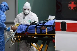 Nhân viên y tế chuyển bệnh nhân nhiễm COVID-19 từ xe cứu thương vào một bệnh viện dã chiến ở Lombardy, Italy ngày 23/3/2020. (Ảnh: AFP/TTXVN)