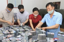 Người dân Triều Tiên chuẩn bị các tờ truyền đơn có nội dung chống Hàn Quốc. (Ảnh: AFP/TTXVN)