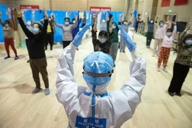 Nhân viên y tế hướng dẫn bệnh nhân nhiễm COVID-19 đang dần hồi phục tập thể dục tại bệnh viện ở Vũ Hán, tỉnh Hồ Bắc, Trung Quốc, ngày 25/2/2020. (Ảnh: THX/TTXVN)