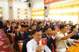 Các đại biểu biểu quyết, thông qua dự thảo Nghị quyết Đại hội Đảng bộ huyện Na Hang, tỉnh Tuyên Quang lần thứ XXII, nhiệm kỳ 2020-2025. (Ảnh: Nam Sương/TTXVN)