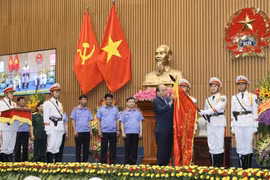 Thủ tướng Nguyễn Xuân Phúc gắn Huân chương Hồ Chí Minh lên lá cờ truyền thống của Viện Kiểm sát Nhân dân Tối cao. (Ảnh: Doãn Tấn/TTXVN)