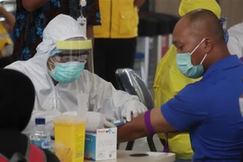 Nhân viên y tế xét nghiệm COVID-19 nhanh cho người dân tại sân bay Juanda, Surabaya, Indonesia ngày 7/4/2020. (Ảnh: THX/TTXVN)
