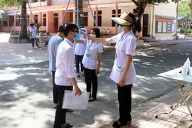 Kiểm tra thân nhiệt cho thí sinh. (Nguồn: TTXVN)