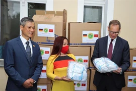 Bà Dương Thị Bích Ngọc (giữa) - Chủ tịch Hội Từ thiện Sen Vàng, thay mặt Hội trao tặng khẩu trang cho Thị trưởng thành phố Berlin Michael Müller (ngoài cùng bên phải). (Ảnh: Anh Đức/TTXVN)